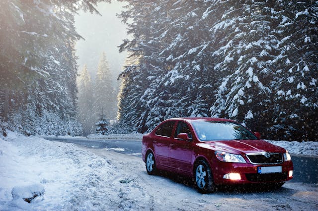 A red car on a snowy road.